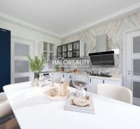 A kitchen in a family house with stylish furnishings, open shelves, and a large refrigerator.