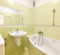 Bathroom in a 3-room apartment, light green tiles, bathtub, sink, mirror, washing machine.
