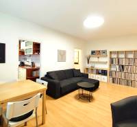 Living room in a 3-room apartment with a sofa, dining table, and a shelf for records.