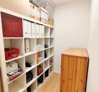 Storage space with a shelving unit and a floor with a wooden decor in a 3-room apartment.