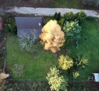 A garden with a cottage in Štitáre surrounded by trees, aerial view.
