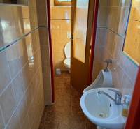 A restroom with a sink and a urinal in commercial premises with ceramic tiles.