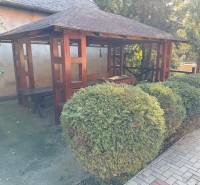 A wooden gazebo surrounded by greenery near commercial premises on Park and main road, Veľké Ludince.