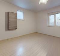 An empty room with a wooden floor in a family house.
