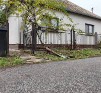 A family house in Hokovce with a garden, a road, and a trash bin by the fence.