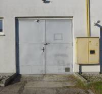 Warehouses and halls in Bratislava - Nové Mesto with gray doors and equipment on the facade.