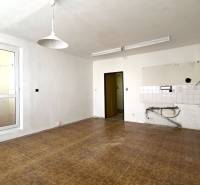 Empty room with white walls, wood-patterned floor, and white light.