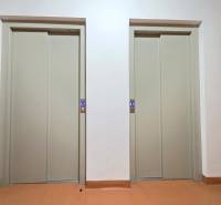 Two closed elevators in a building with white walls and a colorful floor.