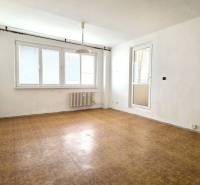 A room with a wooden floor, white walls, and a large window.