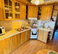 Kitchen unit in a 4-room apartment with a wood-patterned floor and a microwave.