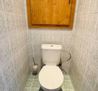 Bathroom in a 4-room apartment with gray tiles and a green carpet.