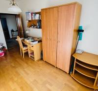 A room with a wooden floor decor, a desk, and a wardrobe in a 4-room apartment.