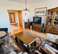 Living room with a sofa set, TV, cabinet, and wooden decor flooring in a 4-room apartment.