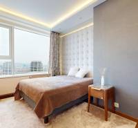 A bedroom in a 3-room apartment with a large window, carpet, and furniture.