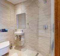 Bathroom in a 3-room apartment with textured walls, a toilet, and a shower.