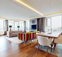 Living room of a 3-room apartment with a sofa set, dining table, and wooden decor flooring.