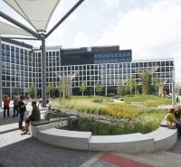City garden with people sitting in a modern business center on Landererova Street.
