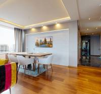 Living room in a three-room apartment with a colorful sofa and a dining table.