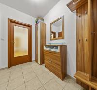 A hallway in a 2-room apartment with wooden furniture and wood-decor paneling.