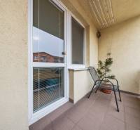 The balcony of a 2-room apartment on Veltlínska Street in Pezinok with a flower and a chair.