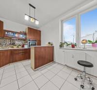 A kitchen in a 2-room apartment with tiles, a window, and a kitchen unit.