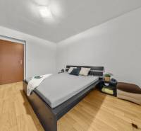 Bedroom in a 2-room apartment with a bed, wardrobe, and floor with a wooden decor.