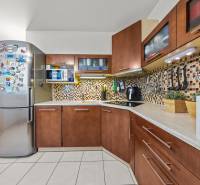 A kitchen with tiles, a decent kitchen unit, a refrigerator, and appliances in a 2-room apartment.