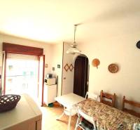 Dining room in a 3-room apartment with a wood-patterned floor and a view of the terrace.