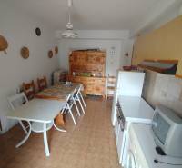 A kitchen with a dining table and chairs in a 3-room apartment with a wooden decor floor.