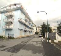 Minzoni Street in Scalea with a building and 3-bedroom apartments, cloudy sky.