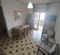 Dining area in a 2-room apartment with a hexagonal tile floor and a balcony.