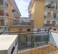 A balcony with a view of apartment buildings on 1 Maggio Street in Scalea, a 2-room apartment.