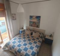 Bedroom in a 2-room apartment with a bed, nightstands, and art on the wall.