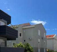 The exterior of apartment buildings in Novalja, ideal for a 3-bedroom apartment, clear sky.