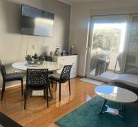 Living room of a three-room apartment with a wooden decor floor and a balcony.