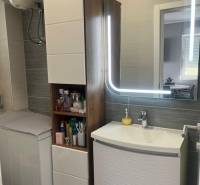 Bathroom in a 3-room apartment with a sink, mirror, and cabinet for toiletries.