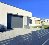 A family house in Mosonmagyaróvár with a clean facade, terrace, and landscaped garden.