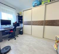 A workspace in a family house with a computer desk, chair, and built-in wardrobe.