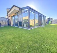 A glazed terrace and a children's playground at a family house in Mosonmagyaróvár.