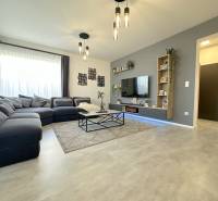 Living room in a family house with a large sofa and a floor with a wooden decor.