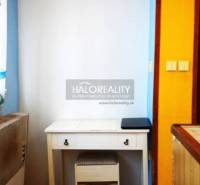 A desk in a studio apartment with a wooden decor floor.