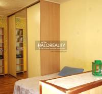 Interior of a 1-room apartment with colorful walls, a mirrored wardrobe, and a floor with a wooden decor.