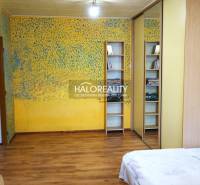 Interior of a 1-room apartment with yellow walls, a mirrored wardrobe, and a floor with a wooden decor.