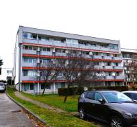 Apartment building on Podbrezovská Street in Bratislava - Rača, with adjacent parking spaces.