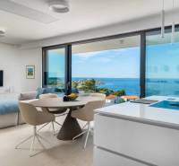 A holiday apartment with a sea view, bright interior with large windows and a kitchen island.