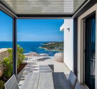 View from a holiday apartment in Rogoznica. Table, chairs, and loungers facing the sea.