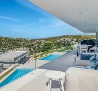 The terrace of a recreational apartment in Rogoznica with comfortable seating and a pool, surrounded by beautiful nature.