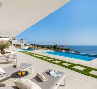 Terrace area with sunbeds, a swimming pool, and a sea view in a holiday apartment in Rogoznica.