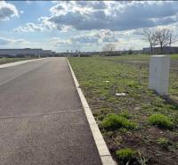 A view of commercial land in Trnava with an asphalt road and green areas.