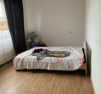 A bedroom in a family house with a bed and a wooden decor floor.